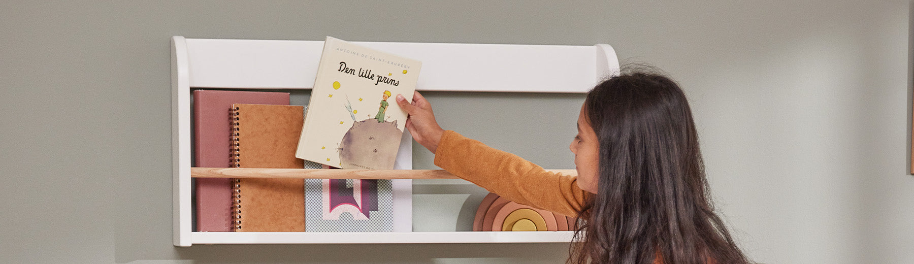 Girl is grabbing a book from her book display shelf from FLEXA