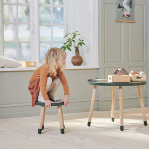 Girl is sitting on the Dots stool from FLEXA 
