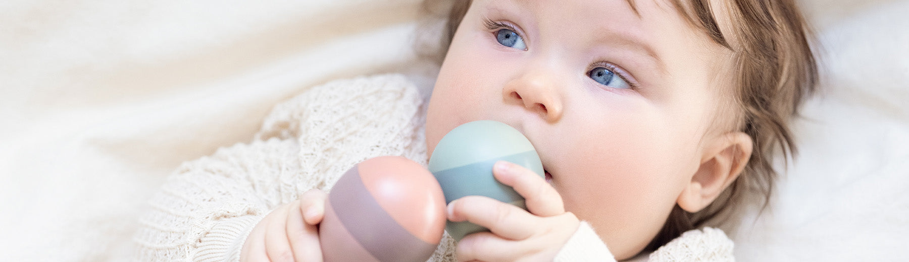 Baby playing with wooden rattle set from FLEXA