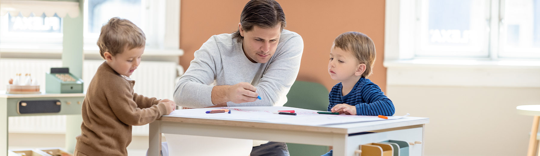 Children sitting around the creative table from FLEXA