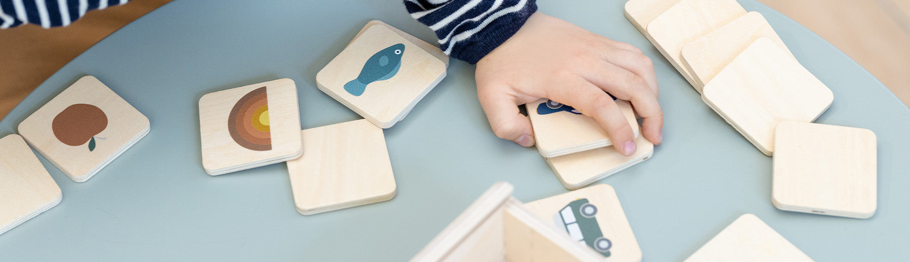 child playing with wooden puzzles from FLEXA