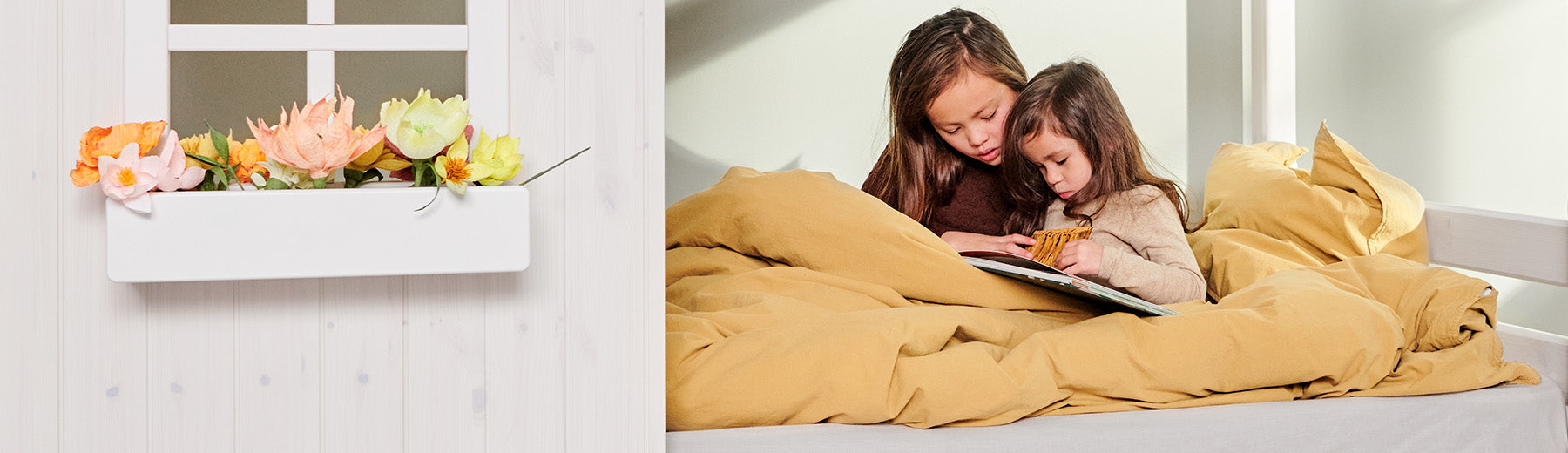 Sisters reading on a mattress from FLEXA