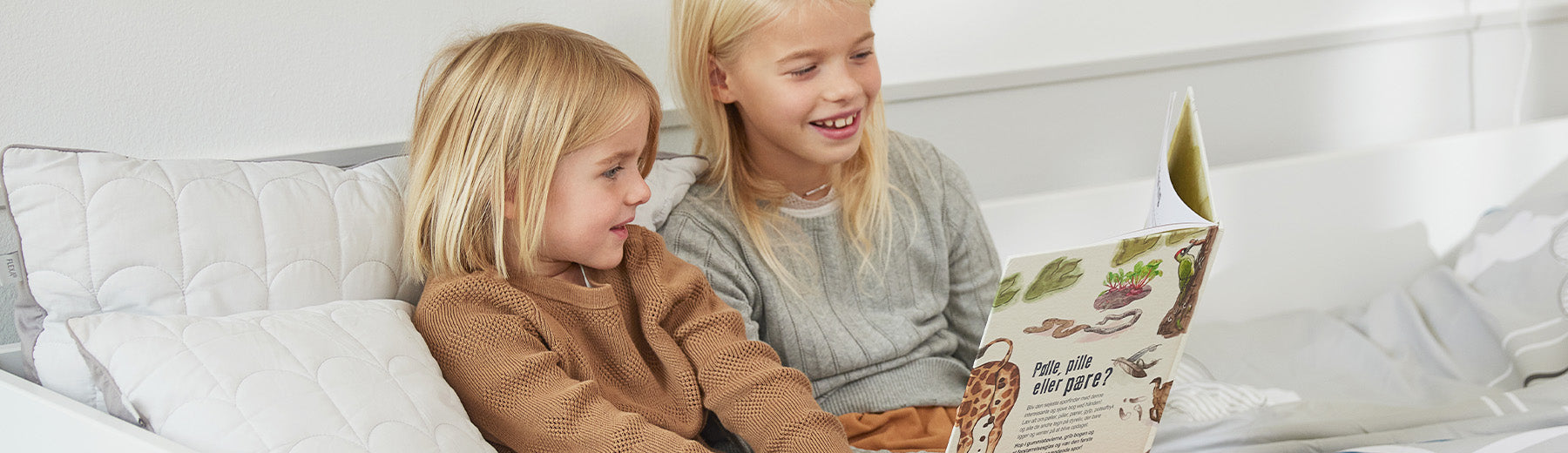 Children reading a book with pillows from FLEXA in the back