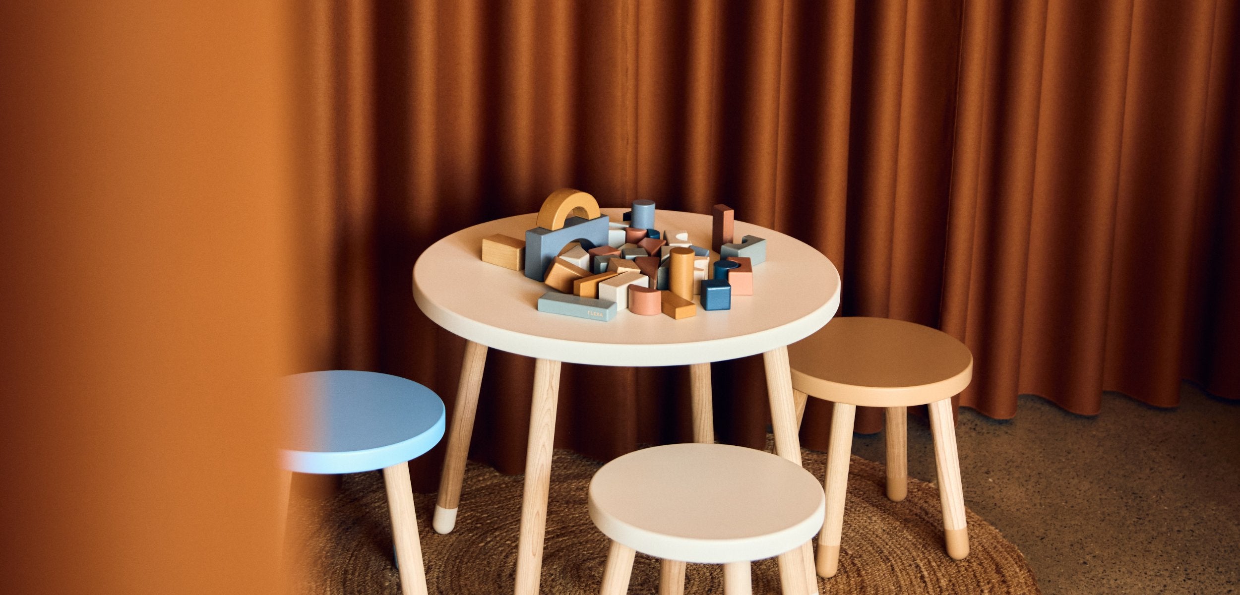 Girl is playing at her wooden play table from FLEXA