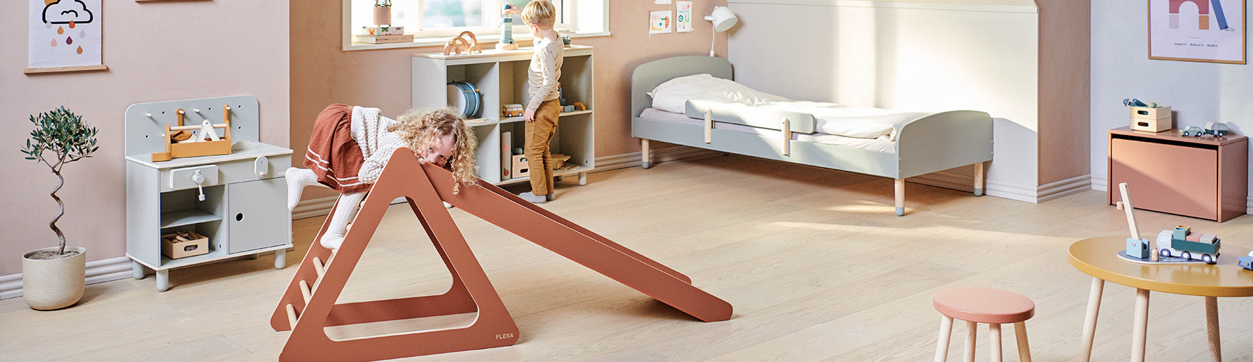 Children playing with a wooden play tower from FLEXA