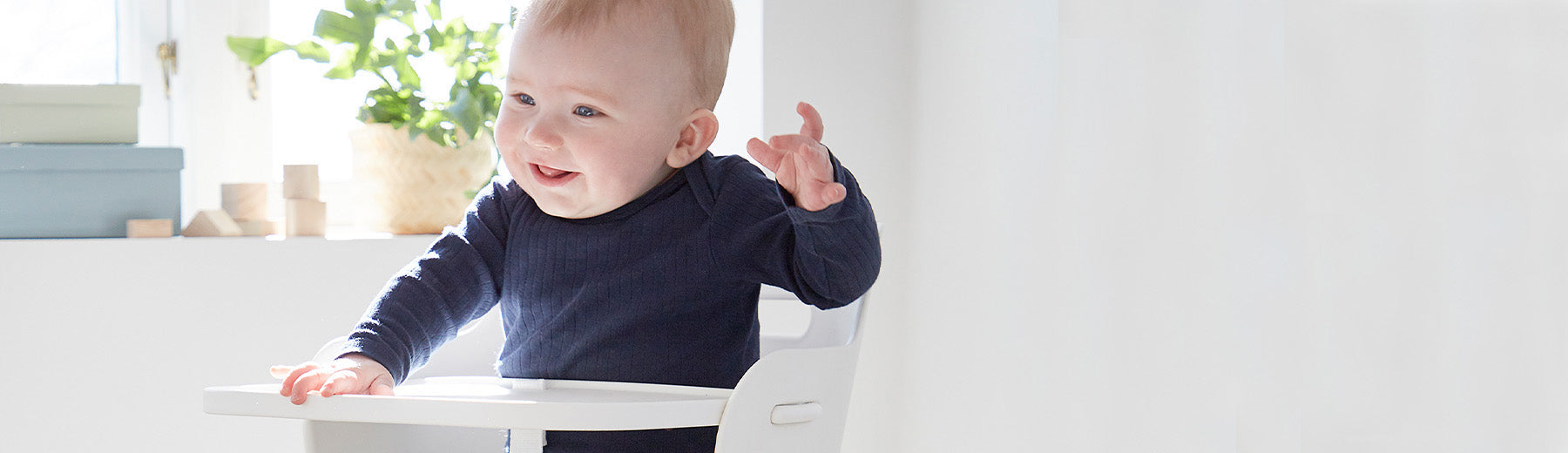 Baby sitting in a high chair from FLEXA