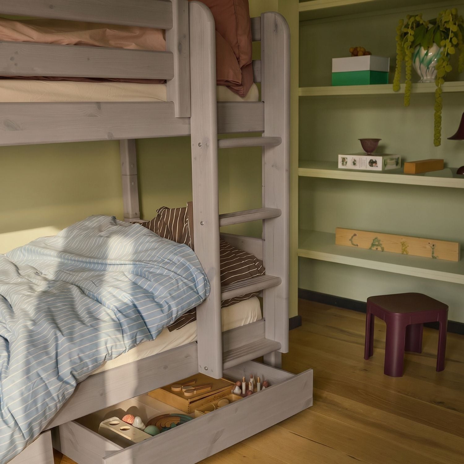 FLEXA CLASSIC Etagenbett mit blau gestreifter Bettwäsche, Leiter, Kiefernholz-Schubladen und Regalen in einem Kinderzimmer; kindersichere Ausführung erkennbar.