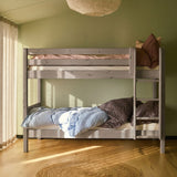 FLEXA bunk bed with straight ladder, white finish, shown in a green-walled sunlit bedroom with wood floors and round rug.