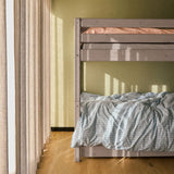 FLEXA bunk bed with straight ladder from the CLASSIC collection, blue and peach bedding, in a bright, child-friendly bedroom.