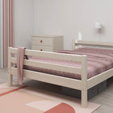 FLEXA single white bed from CLASSIC collection in a minimalist child’s room with pink bedding, dresser, and rug.