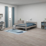 Cama individual FLEXA, de color gris, en un dormitorio infantil de estilo minimalista con toques de azul; se aprecian los bordes redondeados, seguros para los niños.