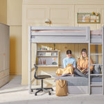 FLEXA grey High Bed with sofa, ladder and safety rail in a bright room with bookshelves, plants and wall art.