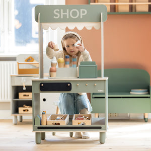 Girl is playing at her shop and café from FLEXA with a wooden ice cream set