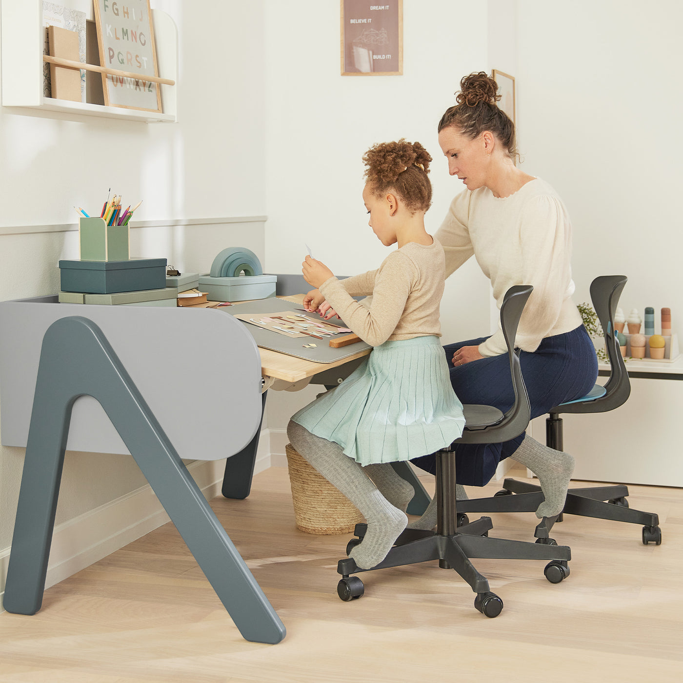 Girl is studying at her Woody Popsicle study table from FLEXA with her mother