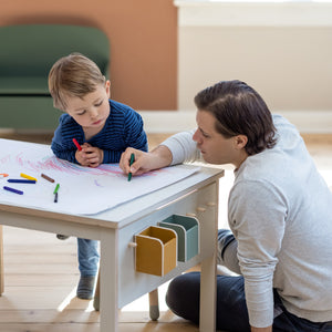 Father and son is drawing at a creative table with paper roll from FLEXA
