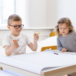 The creative table with paper roll from FLEXA is being used by a boy and a girl