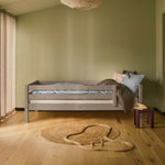 FLEXA single bed in grey from FLEXA collection, shown in a Nordic kids room with child-safe low edges and pastel bedding.