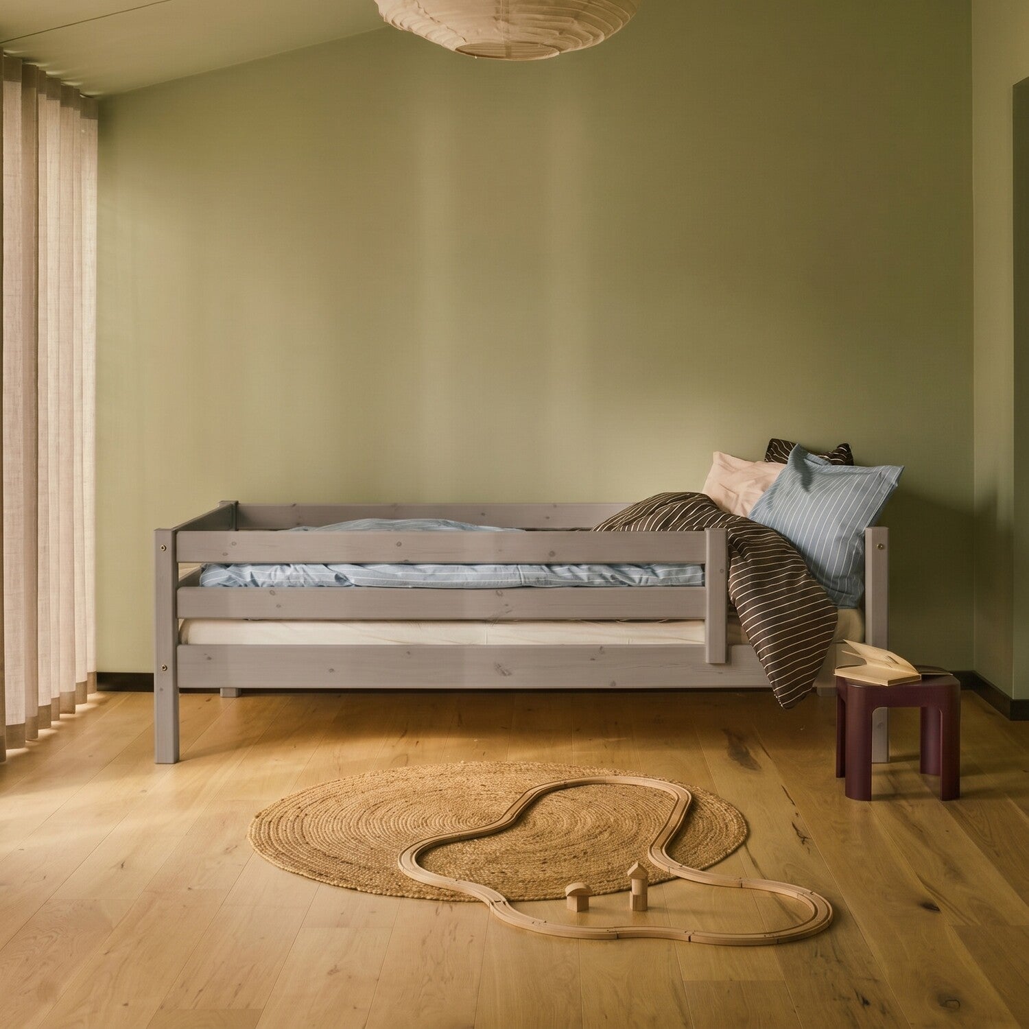 FLEXA single bed in grey from FLEXA collection, shown in a Nordic kids room with child-safe low edges and pastel bedding.